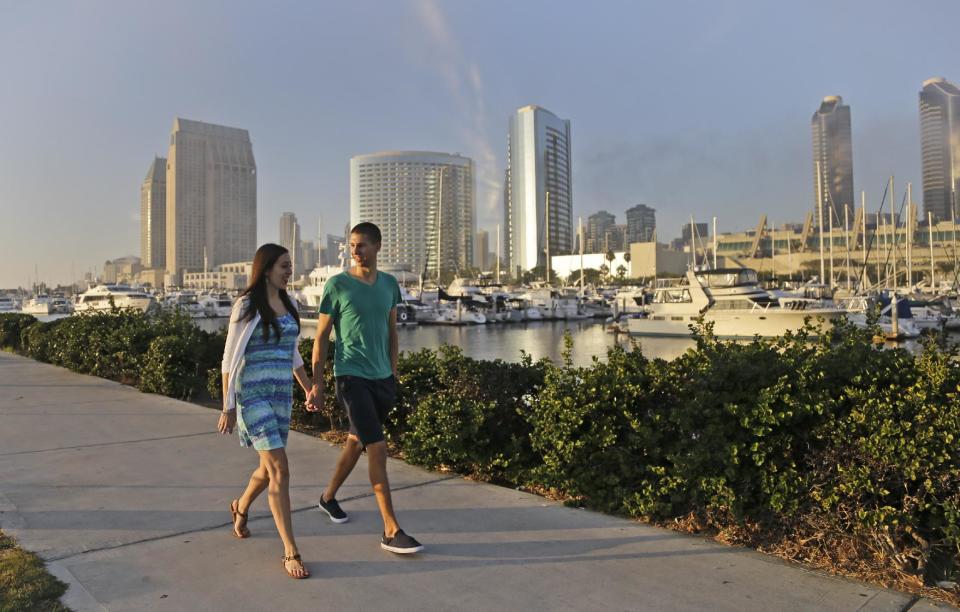 In this Tuesday, Oct. 15, 2013, photo, Melissa Grothues and her fiance John Steele pose at a spot on San Diego Bay in San Diego. The couple left the Buffalo, New York suburb of Amherst seeking a new life with a new environment and landed in San Diego. (AP Photo/Lenny Ignelzi)