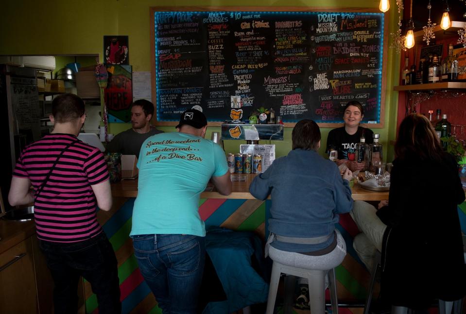 Taco Tontos manager Emma Lasko and Noah Gfell interact with customers at the bar area of the Kent restaurant.