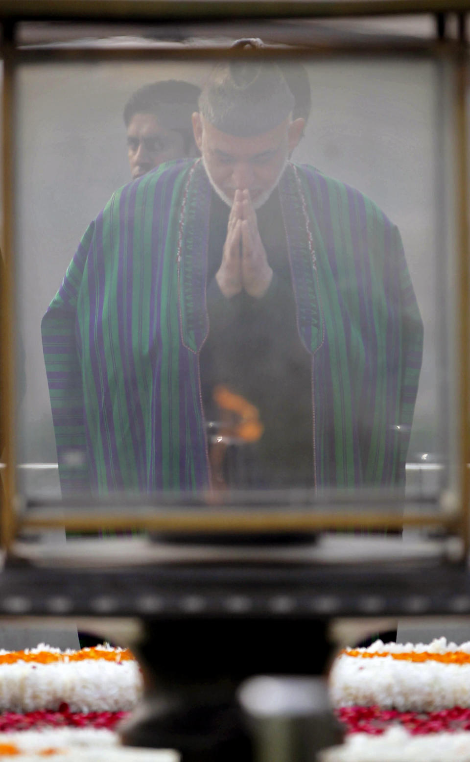 Afghanistan’s President Hamid Karzai offers prayers at Mahatma Gandhi memorial in New Delhi, India, Monday, Nov. 12, 2012. Karzai was meeting with Indian leaders Monday in a bid to woo investment to his war-torn country and boost security before a planned drawdown of NATO troops in 2014. (AP Photo/Mustafa Quraishi)