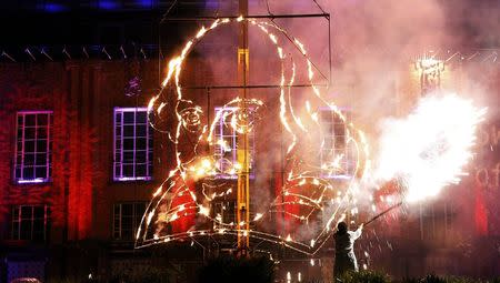 A pyrotechnician lights a flaming depiction of William Shakespeare during a firework display at the Royal Shakespeare Company marking the 450th anniversary of Shakespeare's birth in Stratford-upon-Avon, in this file photograph dated April 23, 2014. REUTERS/Suzanne Plunkett/files