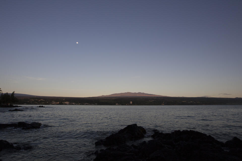 FILE - Mauna Kea, Hawaii's tallest mountain and the proposed construction site for a giant $1.4 billion telescope project, is seen from Hilo, Hawaii, on Aug. 31, 2015. The National Science Foundation said Tuesday, July 19, 2022, that it plans to conduct a study to evaluate the environmental effects of building the Thirty Meter Telescope, one of the world's largest optical telescopes, on sites selected on Mauna Kea in Hawaii and Spain's Canary Islands. (AP Photo/Caleb Jones, File)