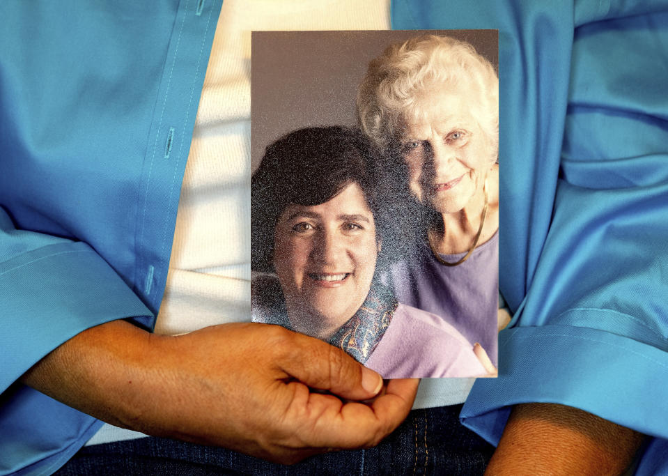 Dorene Giacopini holds a photo of her with her mother, Primetta Giacopini, from her home in Richmond, Calif. on Monday, Sept 27, 2021. Primetta Giacopini's life ended the way it began — in a pandemic. She was two years old when she lost her mother to the Spanish flu in Connecticut in 1918. Giacopini contracted COVID-19 earlier this month. The 105-year-old struggled with the disease for a week before she died Sept. 16. (AP Photo/Josh Edelson)