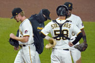 Pittsburgh Pirates relief pitcher Sam Howard, left, walks off the mound after handing the ball to manager Derek Shelton, second from left, during the seventh inning of the team's baseball game against the St. Louis Cardinals in Pittsburgh, Saturday, Sept. 19, 2020. (AP Photo/Gene J. Puskar)