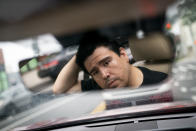 Wallace Reid waits at a stop light in his vehicle he drives to make a living using ride-share apps, Wednesday, June 22, 2022, in the Queens borough of New York. Millions of Americans who rely on their cars for work are changing their habits, signing up for carpools or even ditching their cars for bicycles as gas prices recently hit $5 per gallon for the first time ever. (AP Photo/John Minchillo)