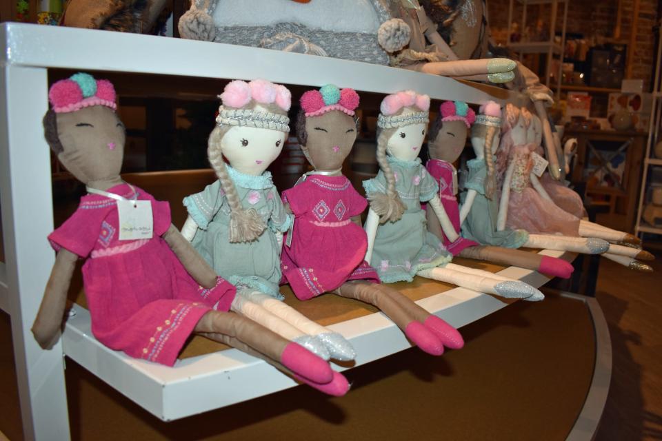 Dolls line a shelf in the retail space at Marmalade Moon on Ames' Main Street.