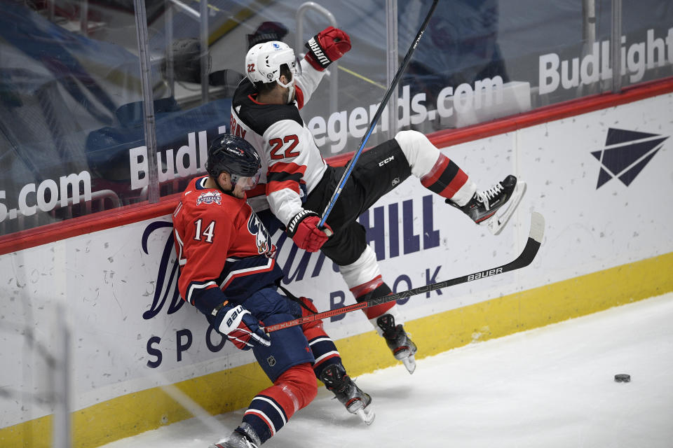 New Jersey Devils defenseman Ryan Murray (22) and Washington Capitals right wing Richard Panik (14) collide along the boards during the first period of an NHL hockey game Tuesday, March 9, 2021, in Washington. (AP Photo/Nick Wass)