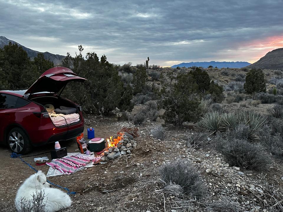 A picture of the Tesla parked in front of a sunset.