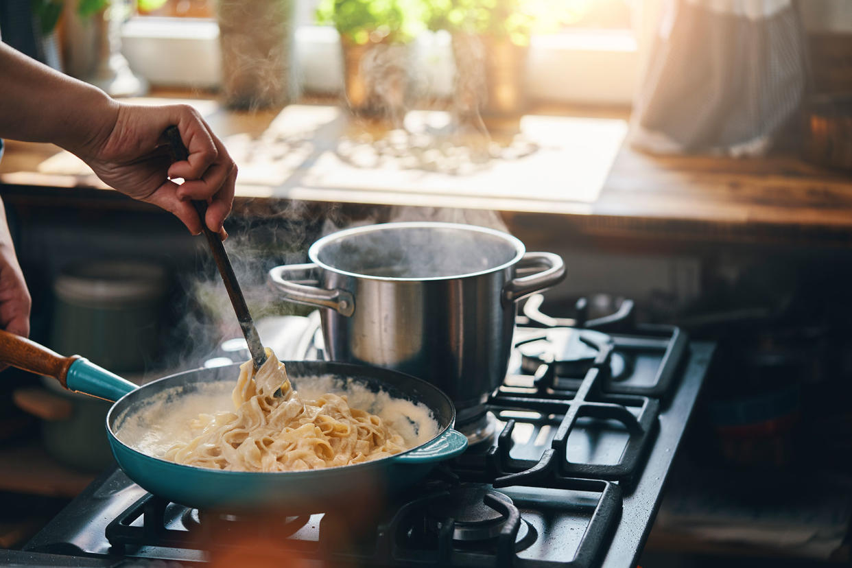 Preparing Fettuccine Pasta Alfredo with Parmesan Getty Images/GMVozd