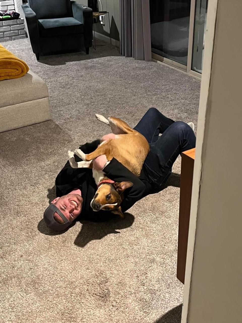 Dexter the dog tackling Jeremy Henson after he and his wife Sarah arrived from Las Vegas.