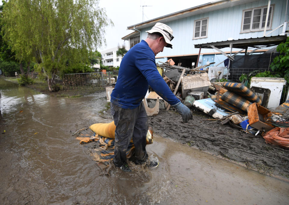 Chris Mitchell removes flood damaged items out of his father in-law’s house in the suburb of Rosslea in Townsville. Source: AAP