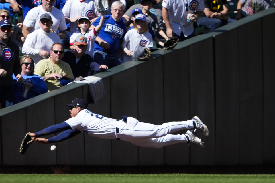Seattle Mariners left fielder Dylan Moore fully extends but can't catch a fly ball in foul territory from Chicago Cubs' Mike Tauchman during the seventh inning of a baseball game Sunday, April 14, 2024, in Seattle. (AP Photo/Lindsey Wasson)