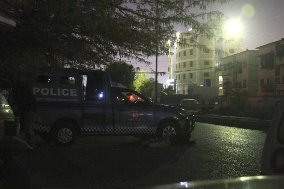 Police officers take position beside their vehicle close to the incident site following gunmen attack on police headquarters, in Karachi, Pakistan, Friday, Feb. 17, 2023. Gunfire erupted outside of police headquarters in Pakistan's largest city on Friday, as security forces rushed to stave off what appeared to be a bold attack in the heart of Karachi, police and officials said. (AP Photo/Ikram Suri)