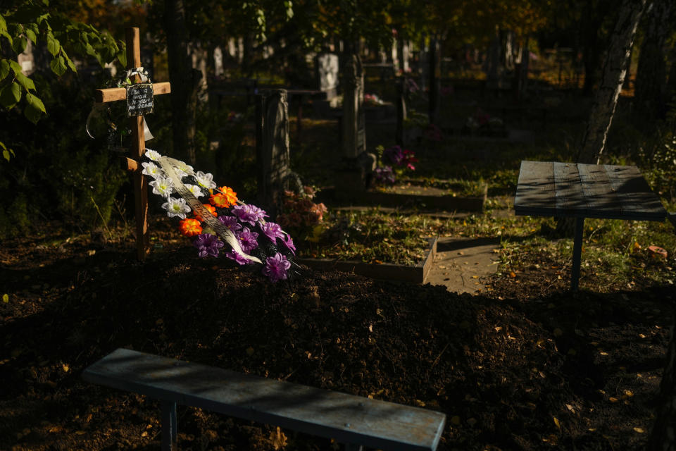 The grave of Mykola Svyryd in a cemetery in Izium, Ukraine, Wednesday, Oct. 12, 2022. A young Ukrainian boy with disabilities, 13-year-old Bohdan, is now an orphan after his father, Mykola Svyryd, was taken by cancer in the devastated eastern city of Izium. (AP Photo/Francisco Seco)