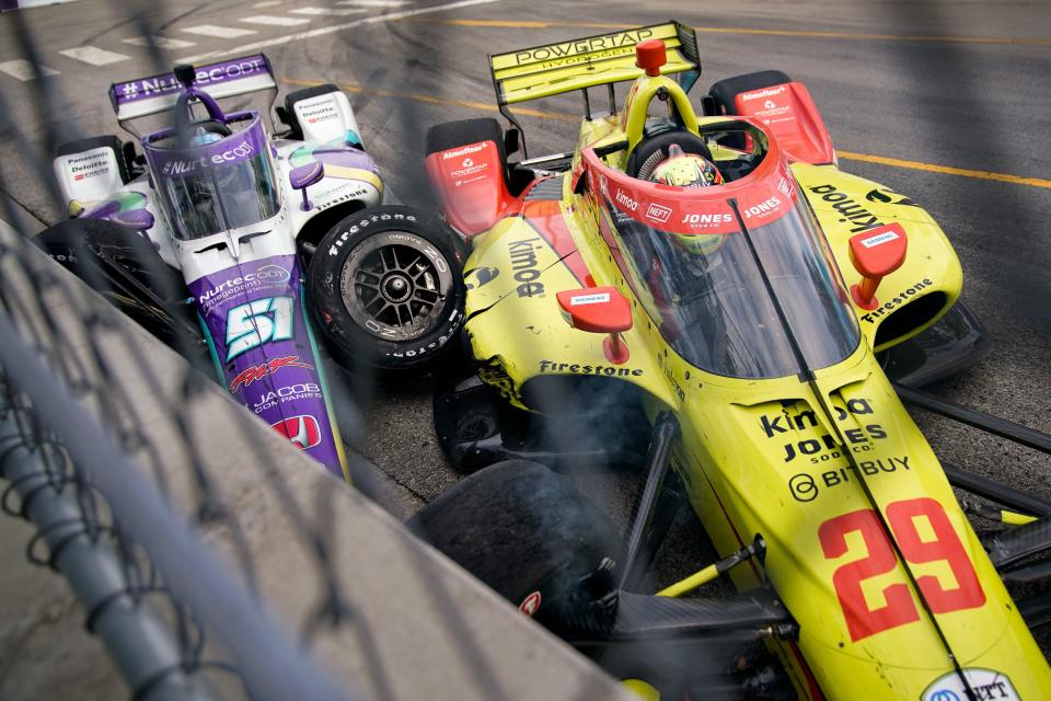 Dale Coyne Racing with Rick Ware Racing driver Takuma Sato (51) of Japan and Andretti Steinbrenner Autosport driver Devlin DeFrancesco (29) of Canada crash during the Music City Grand Prix in Nashville, Tenn., Sunday, Aug. 7, 2022.