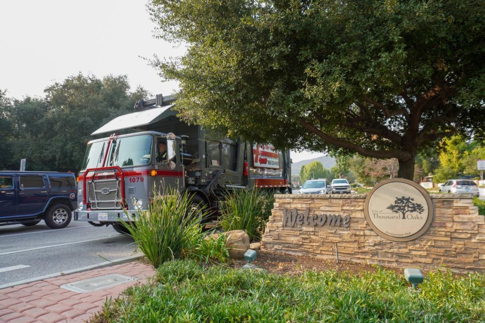 An Athens Services trash hauling truck drives in Thousand Oaks.