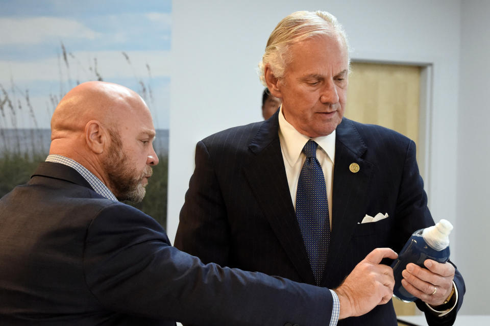 South Carolina Gov. Henry McMaster, right, holds a bottle containing horseshoe crab blood, which is a vital component in the contamination testing of injectable medicines - including the coronavirus vaccines - with Foster Jordan of Charles River Labs on Friday, Aug. 6, 2021, in Charleston, S.C. (AP Photo/Meg Kinnard)