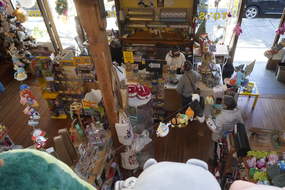 Customers shop at a Five Little Monkeys store in Berkeley, Calif., Monday, Dec. 12, 2022. Small retailers say this year looks much different than the last "normal" pre-pandemic holiday shopping season of 2019. They're facing decades-high inflation forcing them to raise prices and making shoppers rein in the freewheeling spending seen in 2021 when they were flush with pandemic aid and eager to spend. (AP Photo/Jeff Chiu)