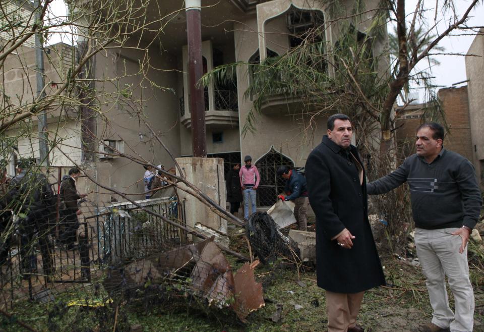 Civilians inspect their damaged house at the site of a car bombing in the Hurriyah neighborhood of northern Baghdad, Iraq, Monday, Feb. 3, 2014. Iraqi officials say car bombings on Monday in and near Baghdad have killed and wounded scores of people. (AP Photo/Hadi Mizban)