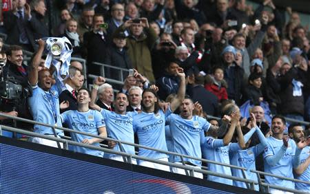 Manchester City captain Vincent Kompany holds aloft the trophy after defeating Sunderland to win the English League Cup final soccer match at Wembley Stadium in London March 2, 2014. REUTERS/Suzanne Plunkett