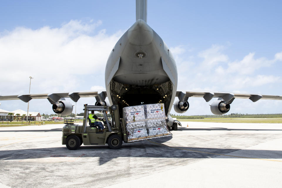 In this photo provided by the Australian Defence Force, personnel unload emergency aid supplies at Tonga's Fuaʻamotu International Airport, near Nukuʻalofa, Thursday, Jan. 20, 2022, after a volcano eruption. U.N. humanitarian officials report that about 84,000 people — more than 80% of Tonga's population — have been impacted by the volcano's eruption. (LACW Emma Schwenke/Australia Defence Force via AP)