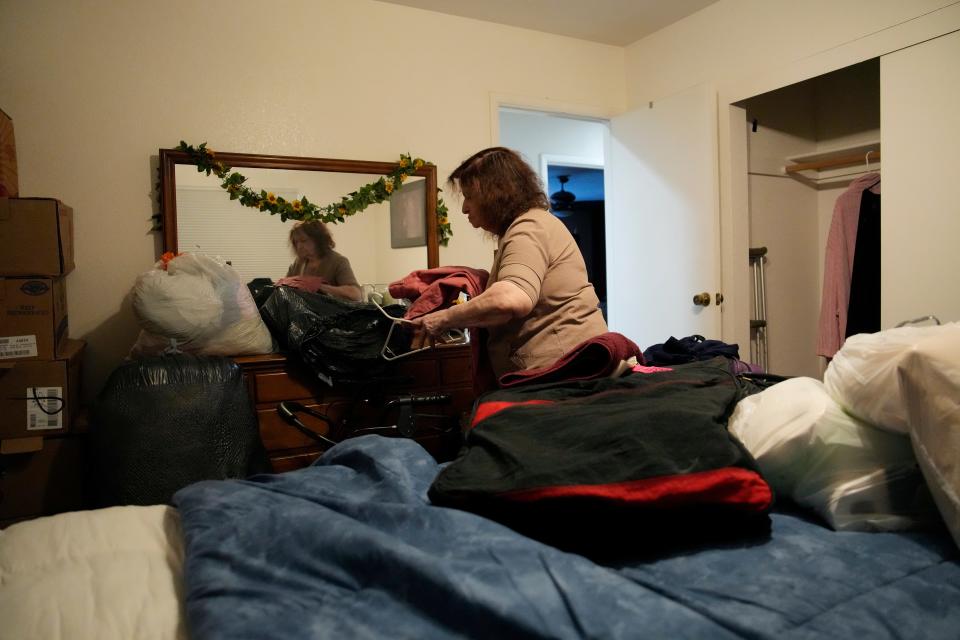 Maria Jackson unpacks clothes into a room she is renting in Las Vegas. Jackson, a longtime massage therapist, lost her customers when the pandemic triggered a statewide shutdown in March 2020 and was evicted from her apartment earlier this year.