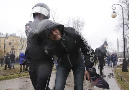 An Interior Ministry officer detains a participant of an opposition protest, calling for Russian President Vladimir Putin not to run for another presidential term next year, in St. Petersburg, Russia, April 29, 2017. REUTERS/Anton Vaganov