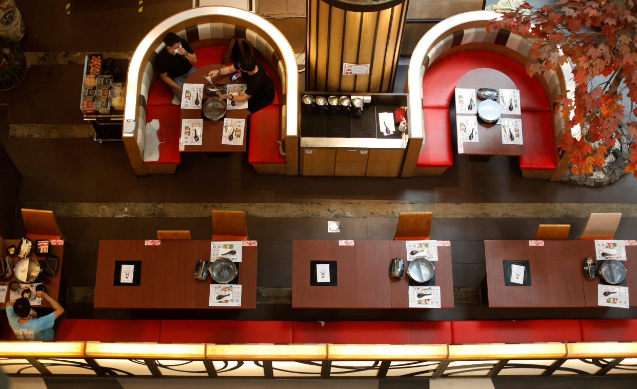 People dine in an empty restaurant during the coronavirus disease (COVID-19) outbreak, in Singapore, August 12, 2020. REUTERS/Edgar Su