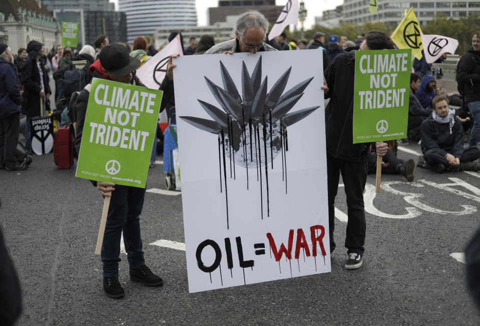 Climate protestors block a road leading to Britain's Parliament in central London Monday, Oct. 7, 2019, in an attempt to disrupt the heart of government. (AP Photo/Matt Dunham)