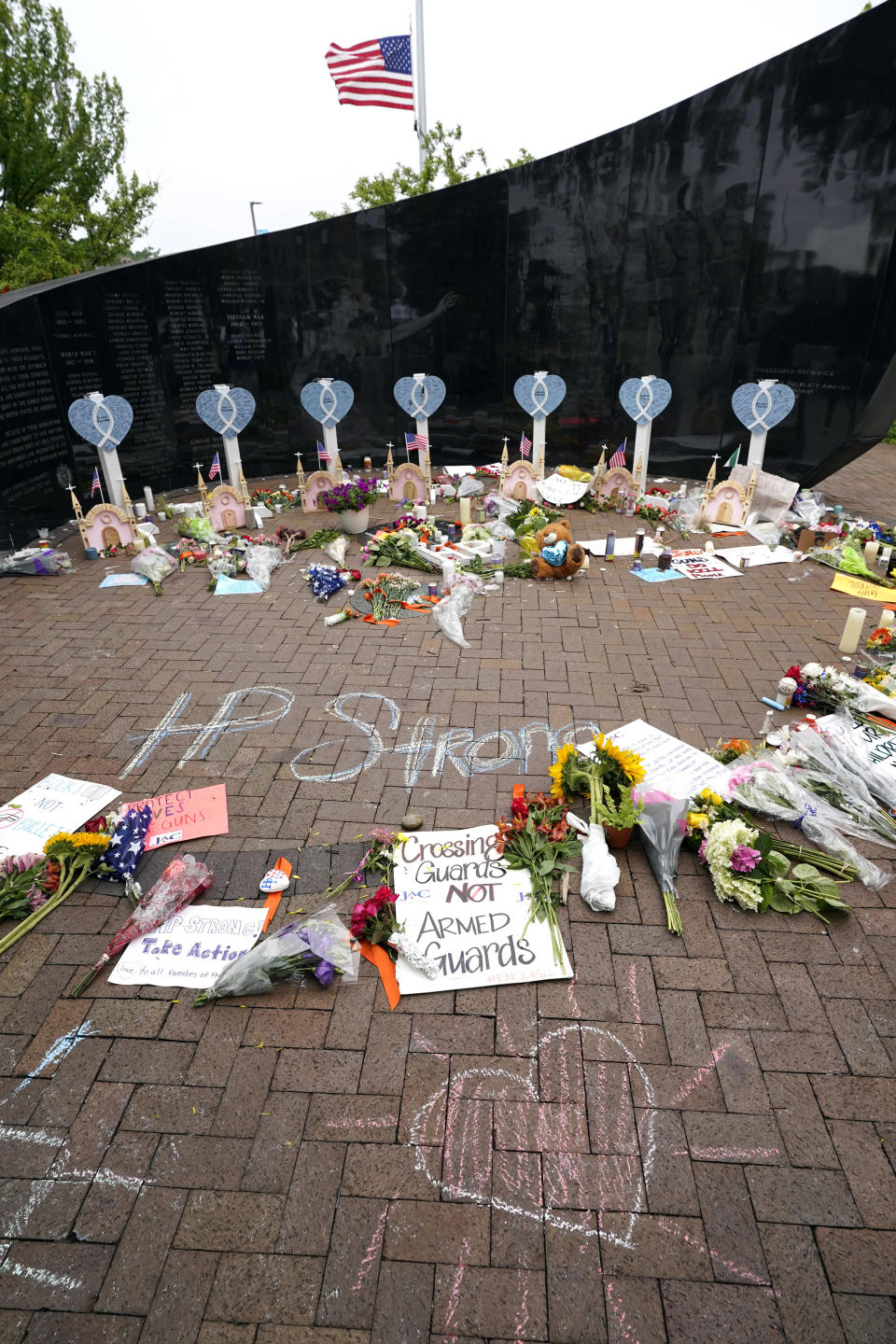 A memorial to the seven people killed and others injured in Monday's Fourth of July mass shooting grows at a veterans memorial Wednesday, July 6, 2022, in Highland Park, Ill. (AP Photo/Charles Rex Arbogast)