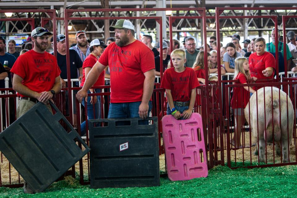 Big Joe's Crew stands with Big Joe after he is weighed during the Big Boar Contest at the Swine Barn on the first day of the Iowa State Fair, Thursday, Aug. 10, 2023, in Des Moines.