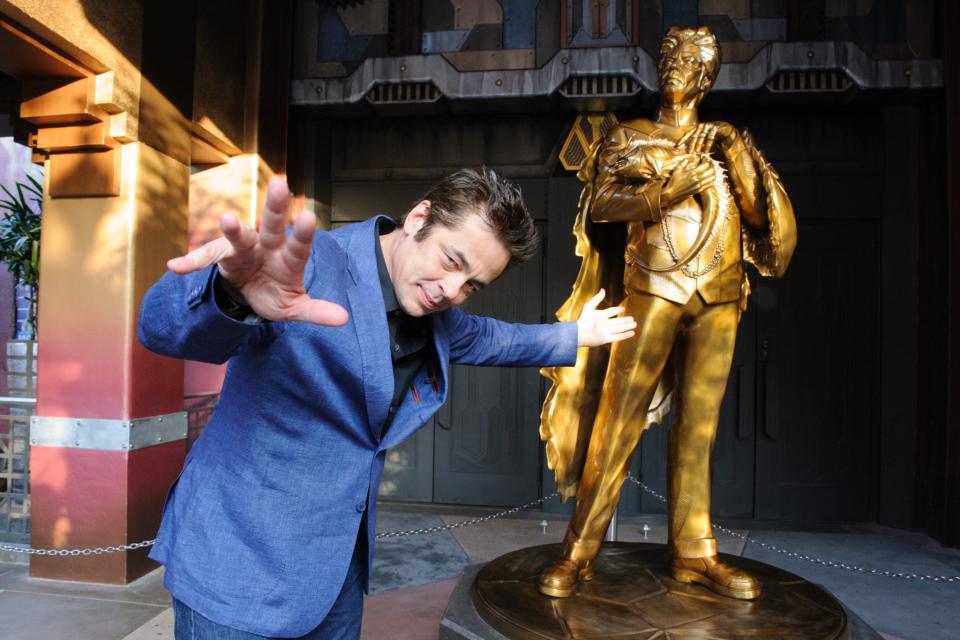 <p>Oscar winner Benicio Del Toro hams it up in front of a golden statue of his character Taneleer Tivan, a.k.a. The Collector, in the foyer of the new ride. (Photo: Disneyland Resort) </p>