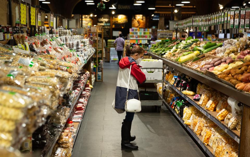 People shop at a supermarket as inflation hits the price of fresh produce.