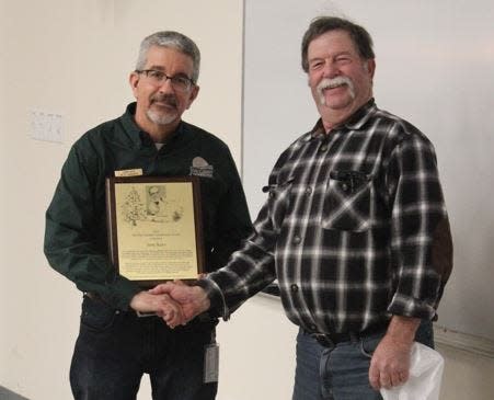 Jerry Keys, left, accepts the 2022 Olav Smedal Conservation Award from Michael Meetz, a former award recipient.