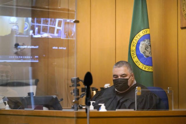 Judge Fa'amomoi Masaniai watches a video feed from a jail courtroom that is also reflected nearby during a hearing for NFL football player Richard Sherman at King County District Court, Thursday, July 15, 2021, in Seattle. Sherman was arrested early Wednesday, police said, after he crashed his car in a construction zone and then tried to break into his in-laws' home in the Seattle suburb of Redmond, Wash. (AP Photo/Elaine Thompson)
