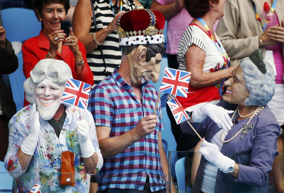 Spectators wearing masks depicting Britain's Royal family hold Union flags during the men's singles first round match between Andy Murray of Britain and Yuki Bhambri of India at the Australian Open 2015 tennis tournament in Melbourne January 19, 2015. REUTERS/Athit Perawongmetha (AUSTRALIA - Tags: SPORT TENNIS SOCIETY)