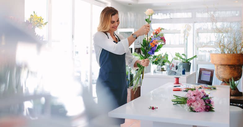 florist arranging flowers in shop