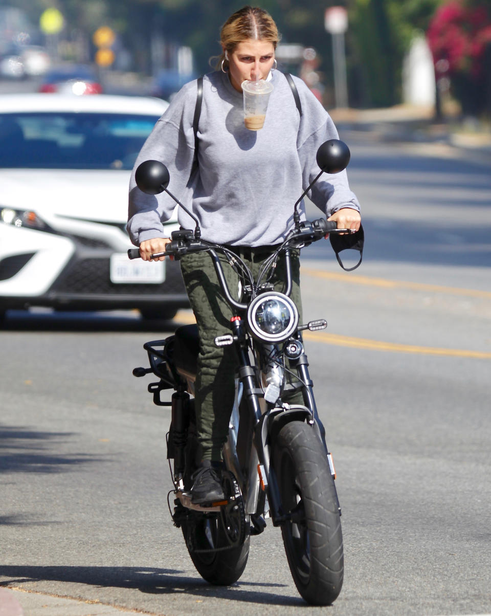 <p><em>Dancing with the Stars</em> pro dancer Emma Slater grabs coffee then hits the streets on her electric bike on Monday in L.A. </p>