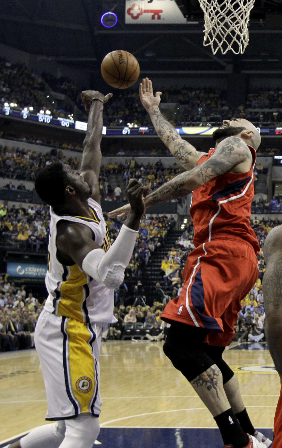 Atlanta Hawks' Pero Antic, right, has his shot blocked by Indiana Pacers' Roy Hibbert, left, during the first half in Game 5 of an opening-round NBA basketball playoff series Monday, April 28, 2014, in Indianapolis. (AP Photo/Darron Cummings)