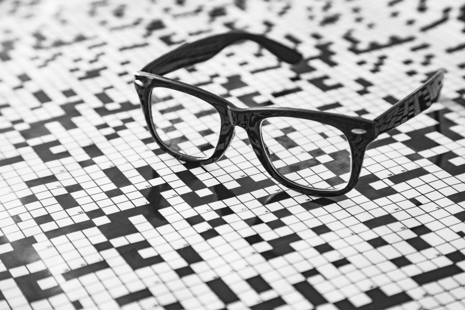 A pair of spectacles with a crossword puzzle background.