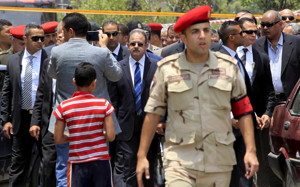 Egyptian Interior Minister Magdy Abdel Ghaffar investigates the site of a car bomb attack on the convoy of Egyptian public prosecutor Hisham Barakat near his house at Heliopolis district in Cairo