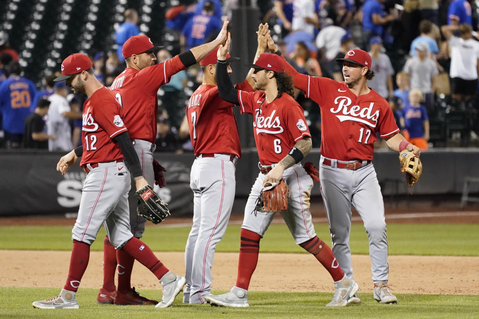 Cincinnati Reds' Tyler Naquin (12), Joey Votto (19), Eugenio Suarez (7), Jonathan India (6) and Kyle Farmer (17) celebrate after defeating the New York Mets in a baseball game, Friday, July 30, 2021, in New York. (AP Photo/Mary Altaffer)