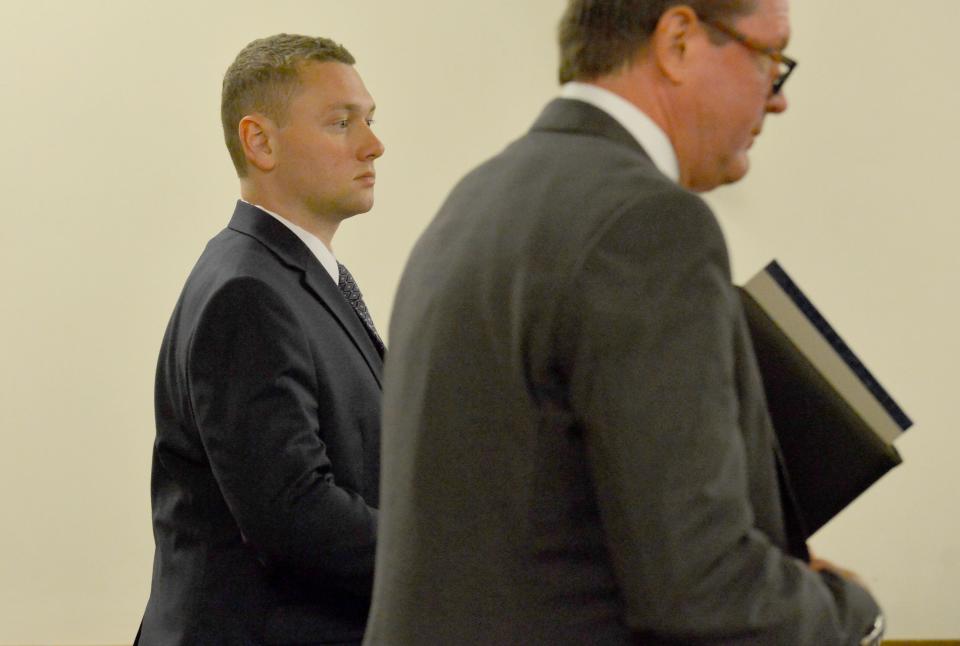 Reid Mason, left, stands next to his attorney Peter Lloyd during his arraignment Wednesday in Barnstable District Court. Mason pleaded not guilty to charges of improper storage of guns.