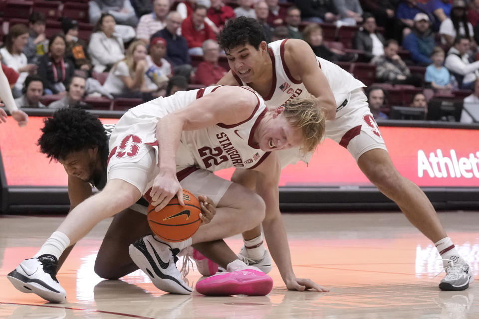 Washington State forward Isaac Jones, left, reaches for the ball under Stanford forward James Keefe (22), as forward Brandon Angel, right, watches during the second half of an NCAA college basketball game in Stanford, Calif., Thursday, Jan. 18, 2024. (AP Photo/Jeff Chiu)