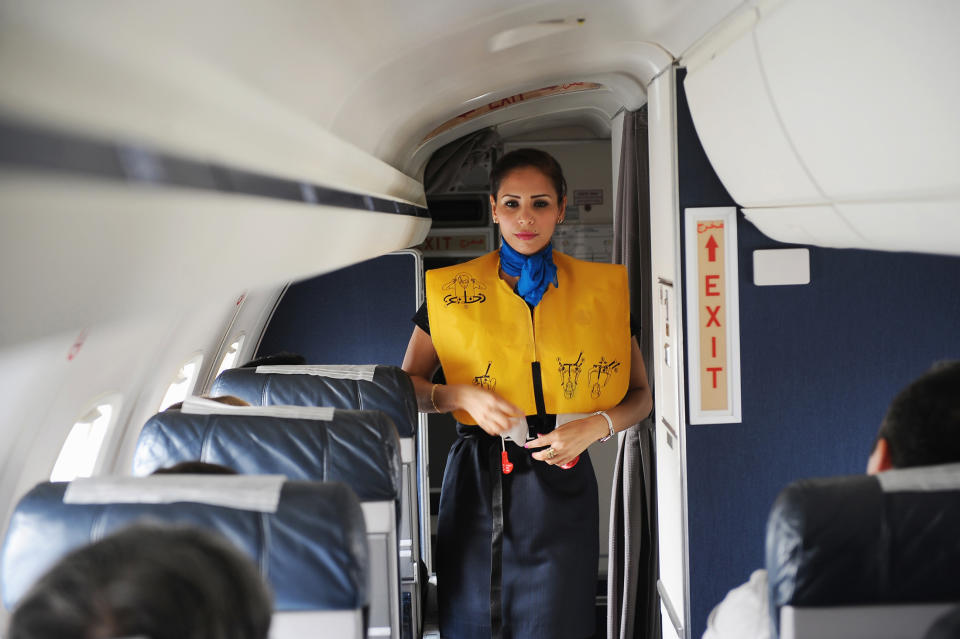 Eine Stewardess im Flugzeug mit Rettungsweste