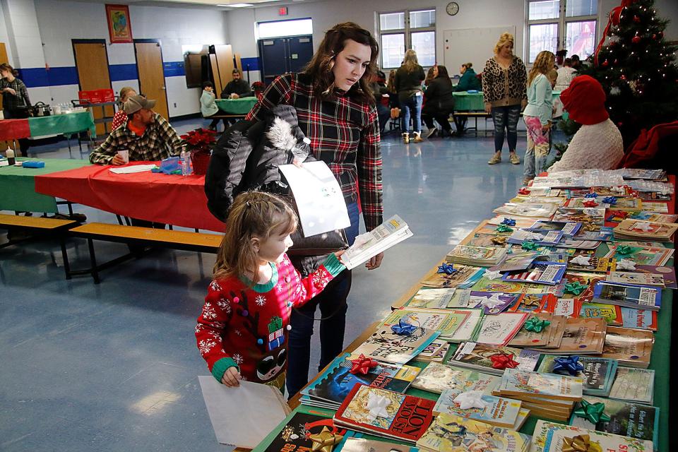 Brinley Pummell picks out books with her mom Brandi at the breakfast with Santa at Mapleton Elementary School on Saturday, Dec. 4, 2021. TOM E. PUSKAR/TIMES-GAZETTE.COM