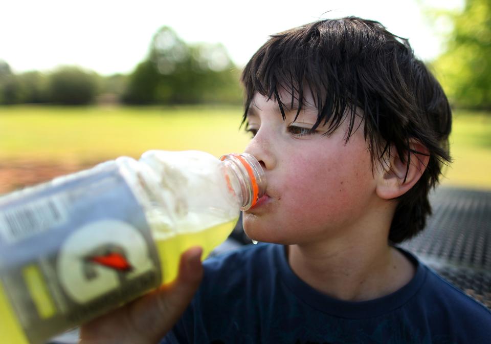 Robert Agnvall, 8, hydrates himself with Gatorade while taking a break from skate boarding with his father Peter at the Possum Creek Skate Park Wednesday, April 20, 2011.  Agnvall is visiting his grandmother here in Gainesville from Washington, D.C. during his spring break. Robert said, "It's a lot hotter here", about Gainesville's weather compared to his home in D.C.  (Doug Finger/The Gainesville Sun)