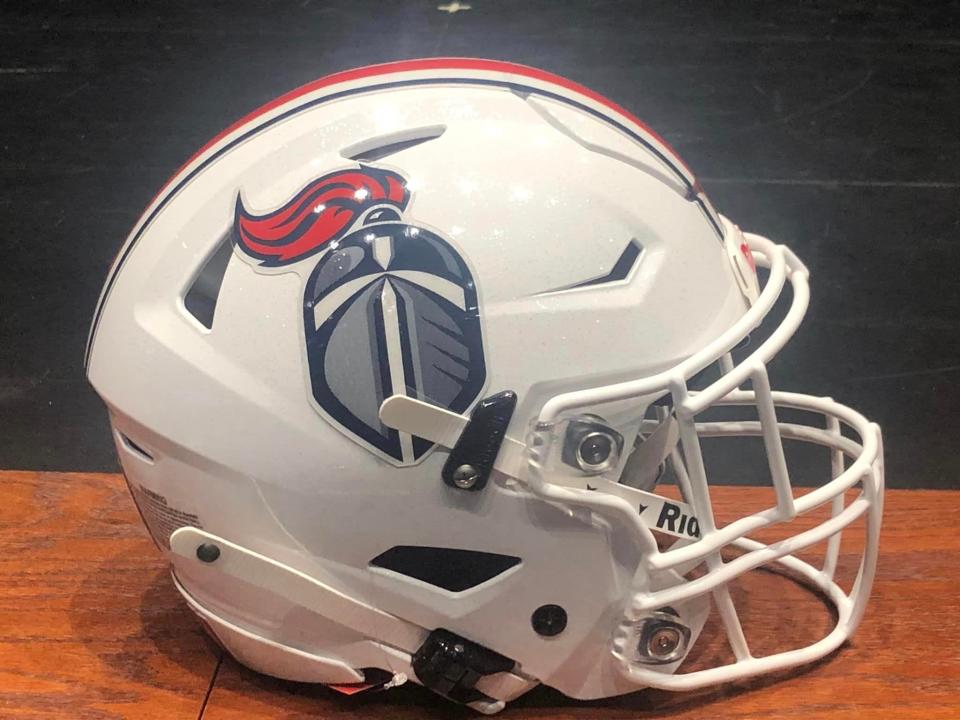 St. Henry football coach Tim Odom unveiled the team's helmet design at a Jan. 25 meeting with freshman interested in playing for the Crusaders.