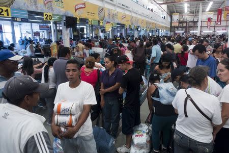 People queue to pay for their items at a Makro supermarket in Caracas August 4, 2015. REUTERS/Carlos Garcia Rawlins