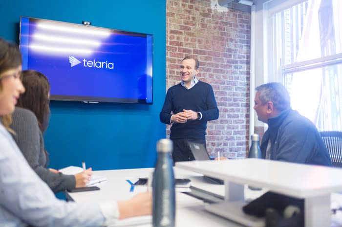 Telaria CEO Mark Zagorski, standing in a conference room and speaking with others seated around a table.