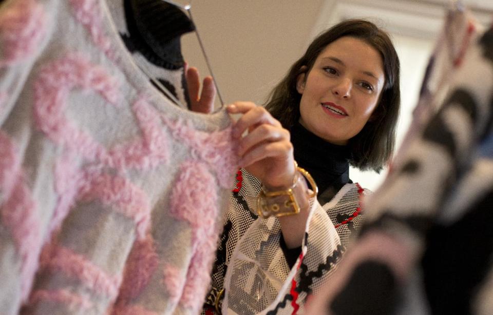 Fashion designer Sam Leutton originally from Stockport northern England, poses for a portrait at her booth in Somerset House, the main center for London Fashion Week, where she is showing her designs in London, Monday, Feb. 17, 2014. A tale of two Britain's has emerged after the Great Recession on this economically hobbled island. While politicians trumpet the country’s recovery from the financial crisis and its status as the world’s fastest growing developed economy, the figures point to a growing divide, one that pits London’s growing boom against the malaise in once-affluent cities such as Manchester that are struggling to remain vibrant in the 21st century.(AP Photo/Alastair Grant)